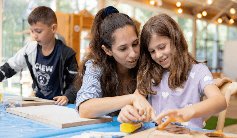אם וילדים יוצרים יחד במהלך סדנה משפחתית במוזיאון.