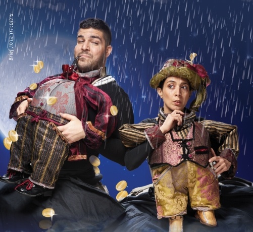שני שחקנים בתלבושות בובות תחת גשם לילי עם מטבעות זהב