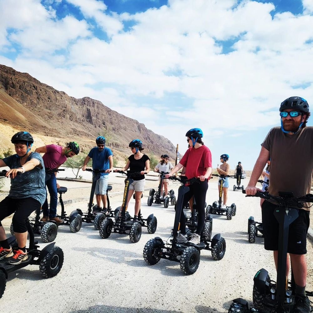 Matzok group tour riders on off road scooters near Dead Sea desert cliffs