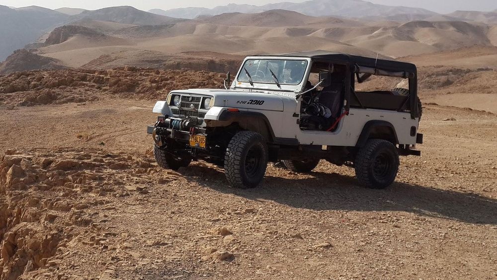 Matzok jeep parked on Judean Desert ridge with panoramic mountain view